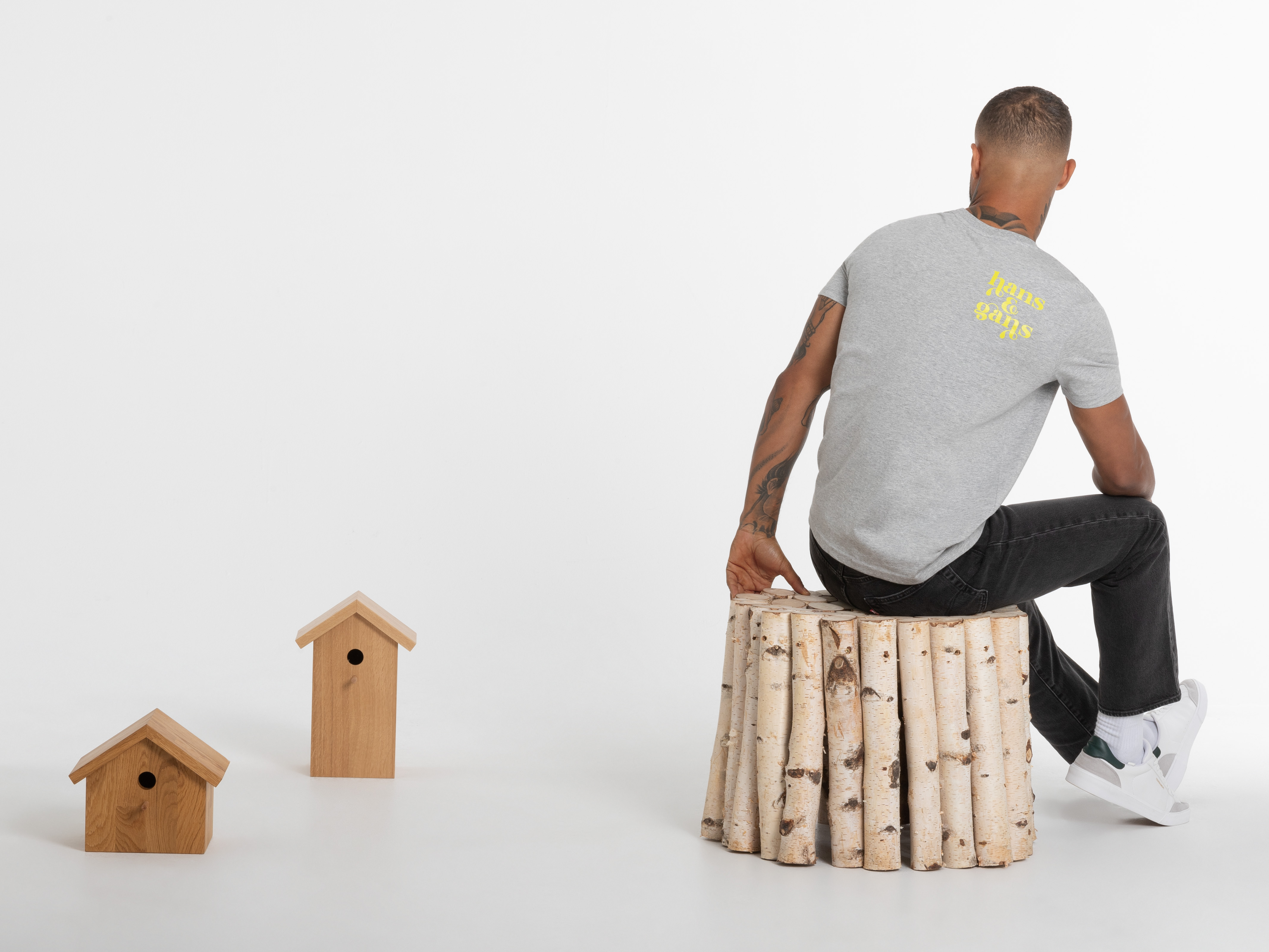 Rückansicht eines Mannes im grauen T-Shirt mit großem gelben Logo – lässiger Streetstyle mit Markenstatement