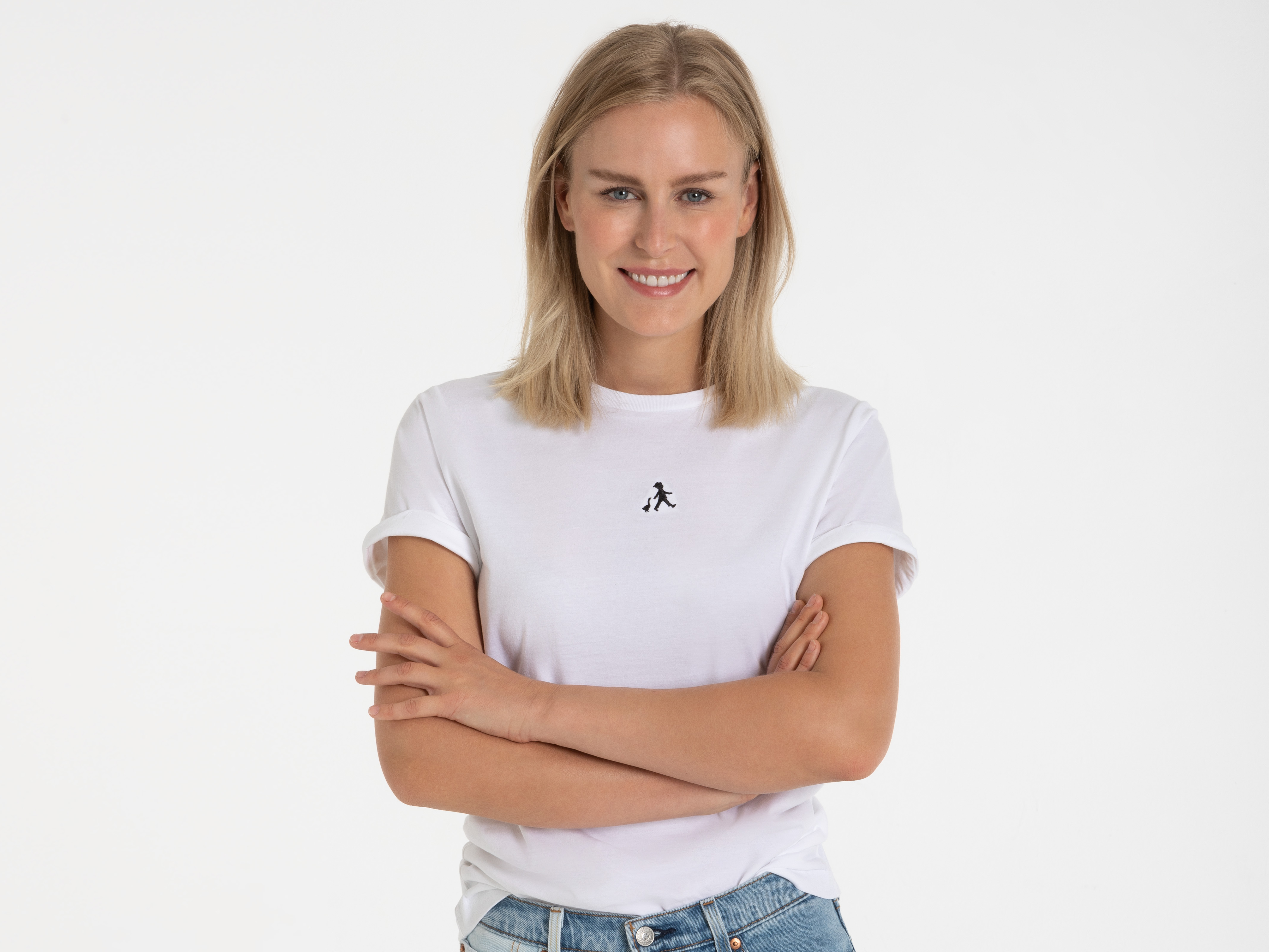 Frau in weißem T-Shirt mit schwarzem ‚Hans im Glück‘-Logo vorne – schlichtes Unisex-Shirt, modern und bequem.