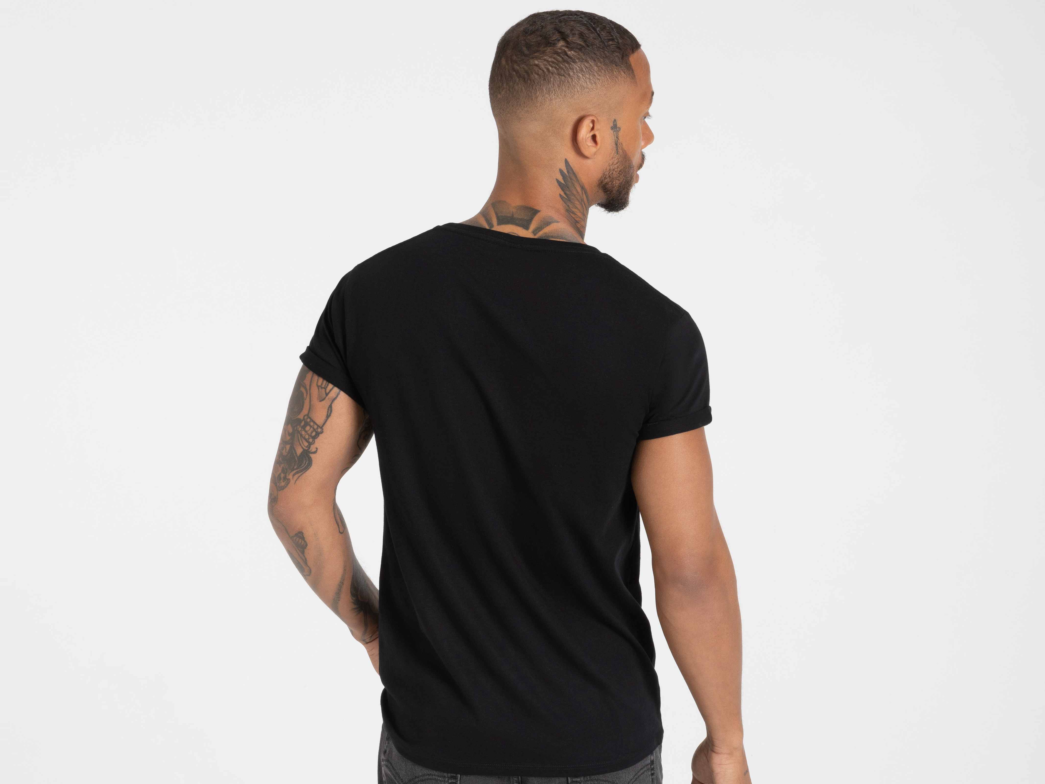 Seitlicher Rückenblick auf schwarzes Shirt mit dezentem Schnitt – klarer, minimalistischer Stil.